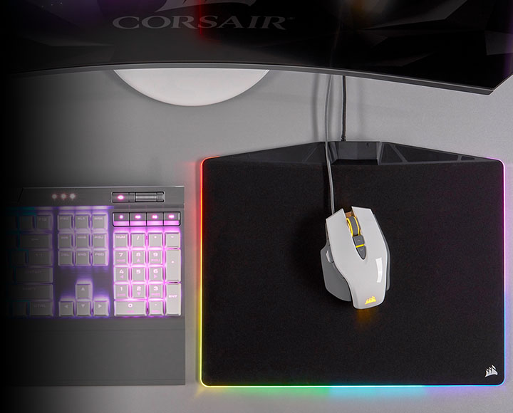 Mouse visto de um ângulo superior junto a um mousepad e teclado Corsair